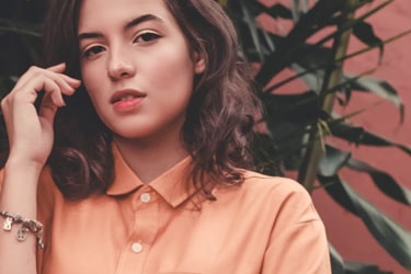 A girl with short hear wearing a pink blouse